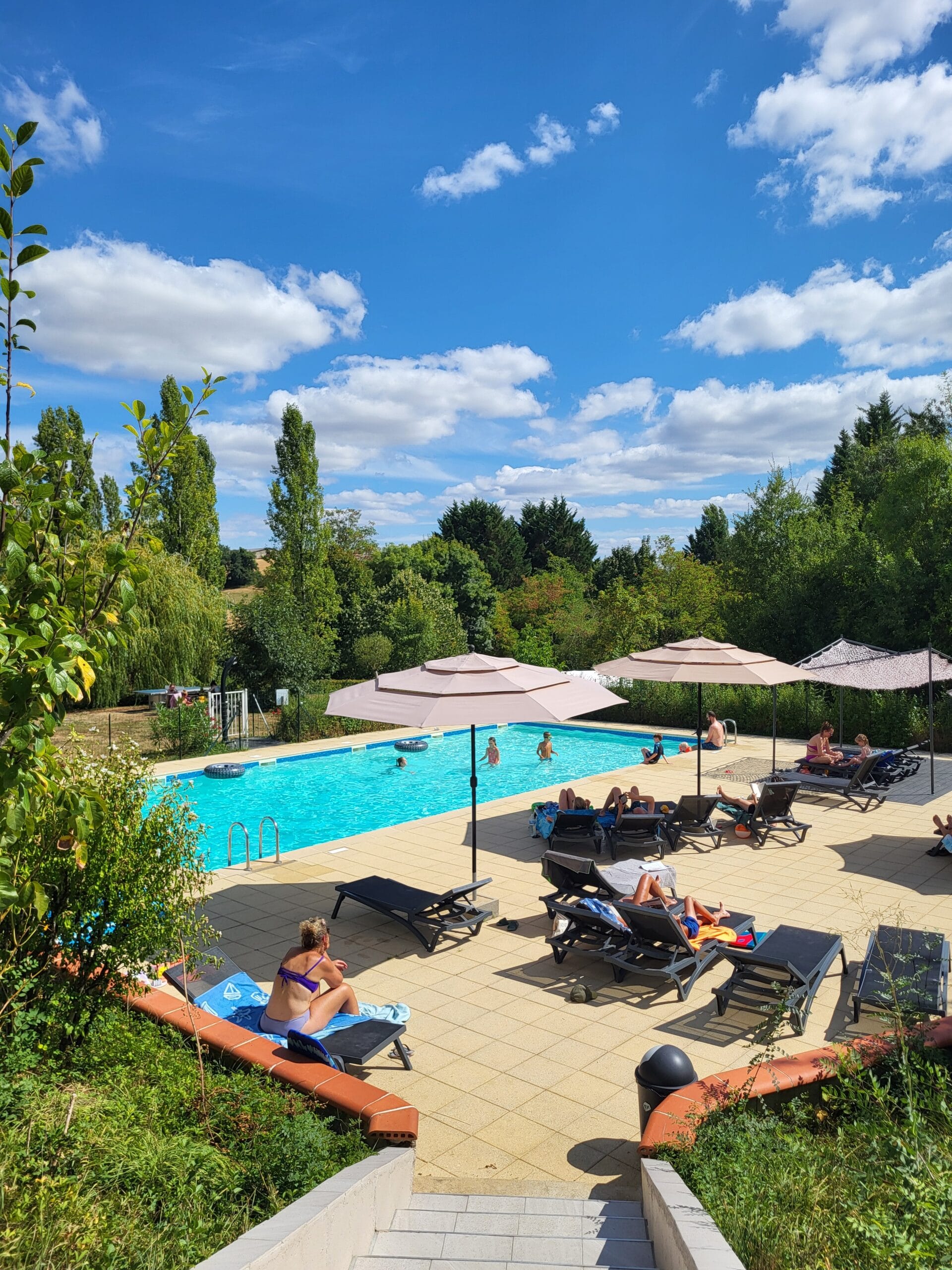 Zwembad 1 Sunny poolside scene with loungers